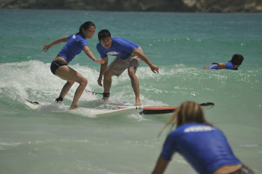 couple surfing together with macao surf camp near punta cana