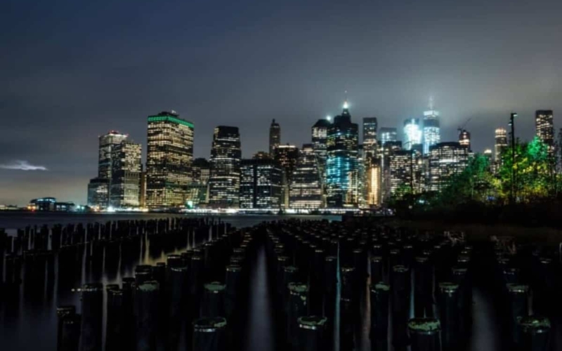 view of nyc lit up at night across the bay