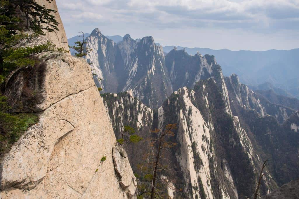 Close to South Peak's summit, things start opening up with great views of the sloping cliffs and the range beyond. 