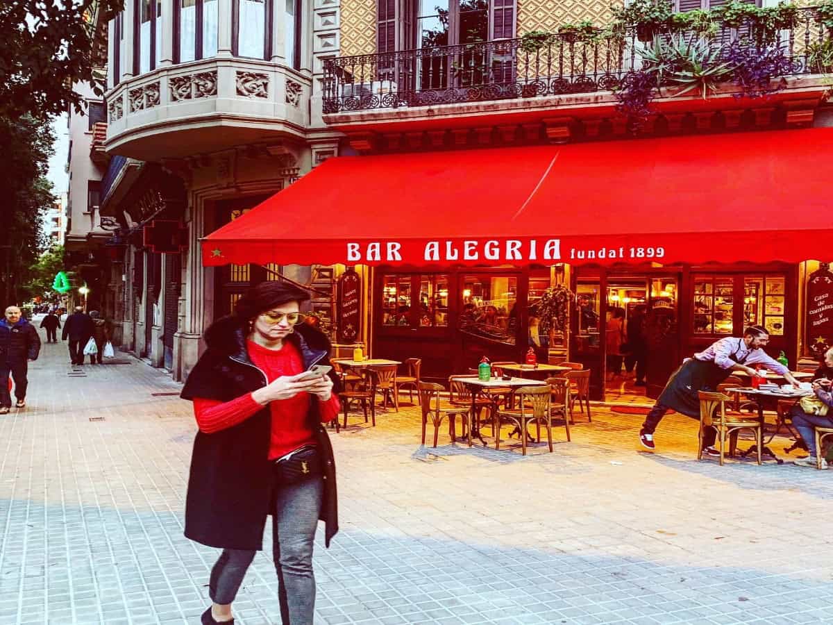 Top 10 Tapas Bars In Barcelona pedestrians walking by bar alegria