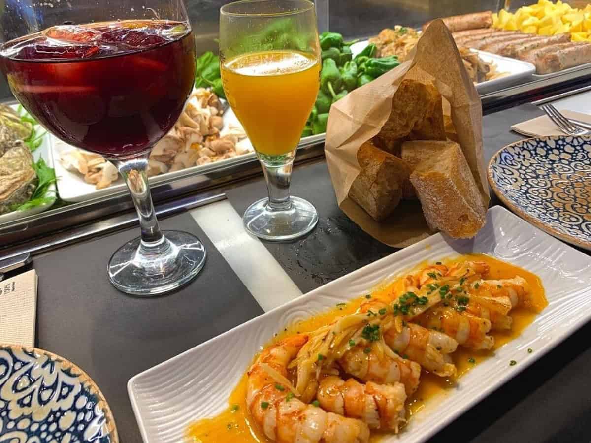 Top 10 Tapas Bars In Barcelona delicious shrimp dish with various drinks at el quim de la boqueria