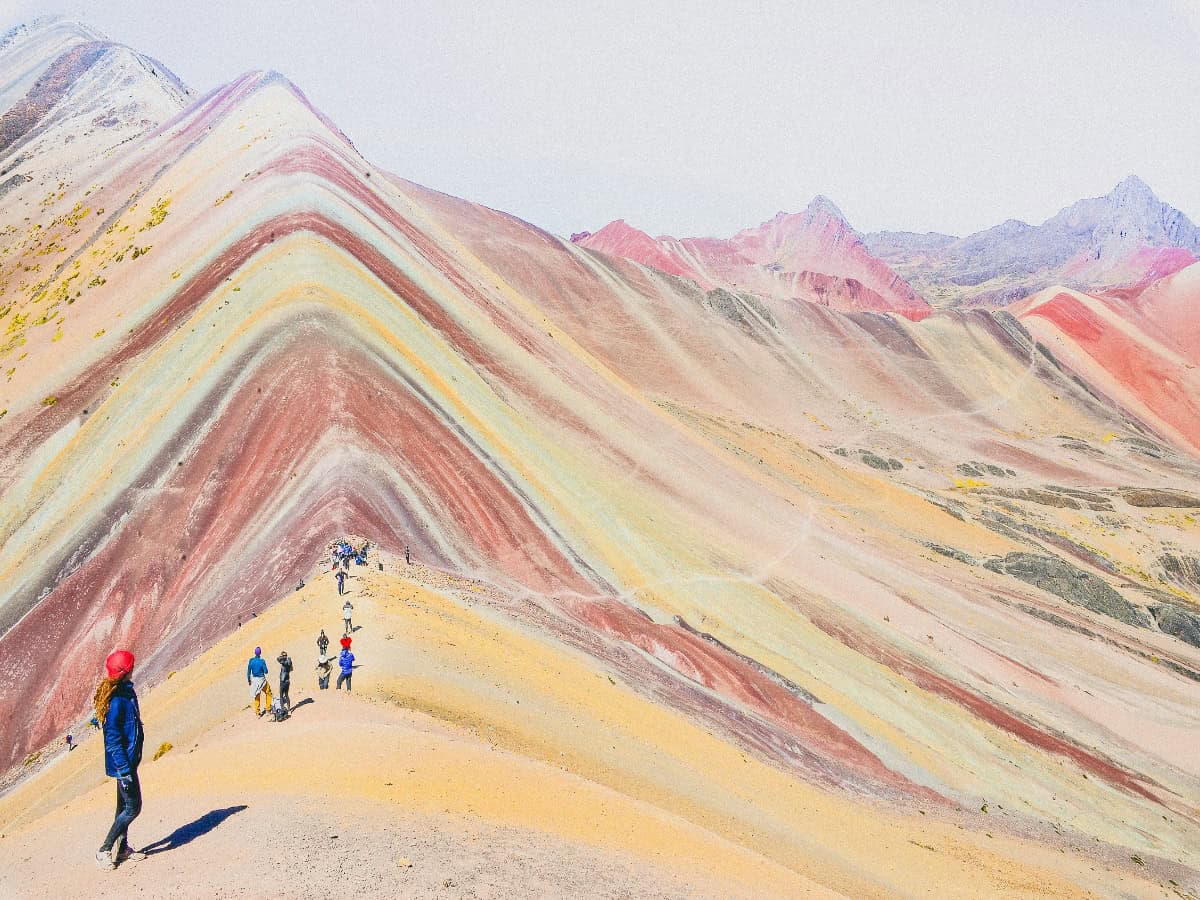 hikers taking in the sights of the rainbow mountain in peru
