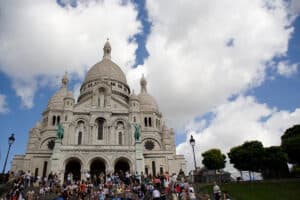 sacre coeur basilica with a crowd of people on the steps in paris itinerary