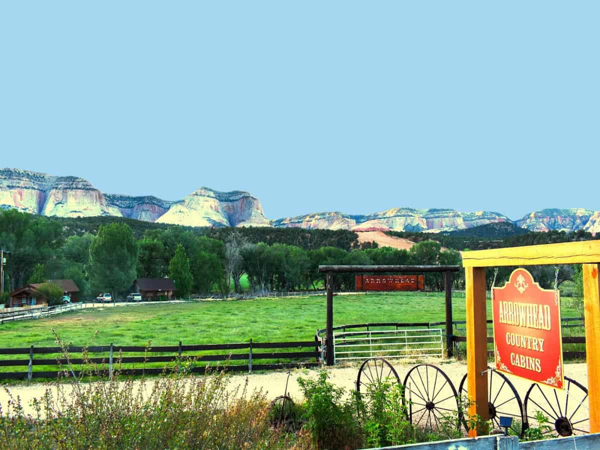 arrowhead country inn sign and cabins in front of cliffs