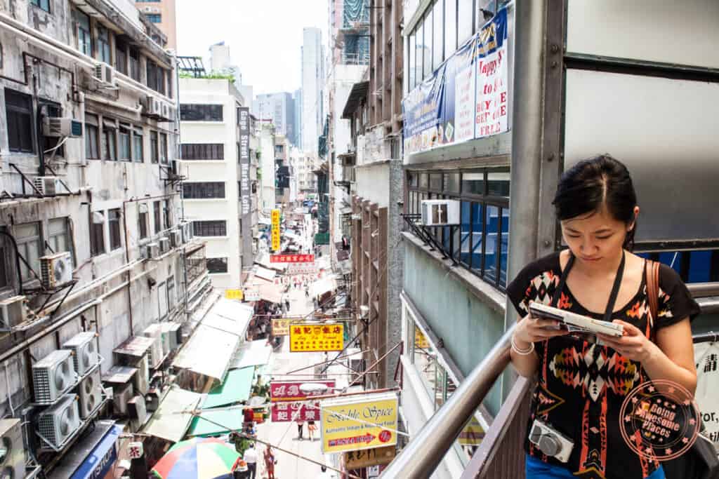 mid levels escalators looking at the street below with woman tourist looking at a map