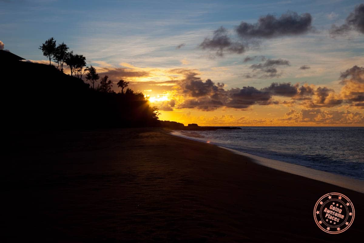 sun setting beyond hawaii beach