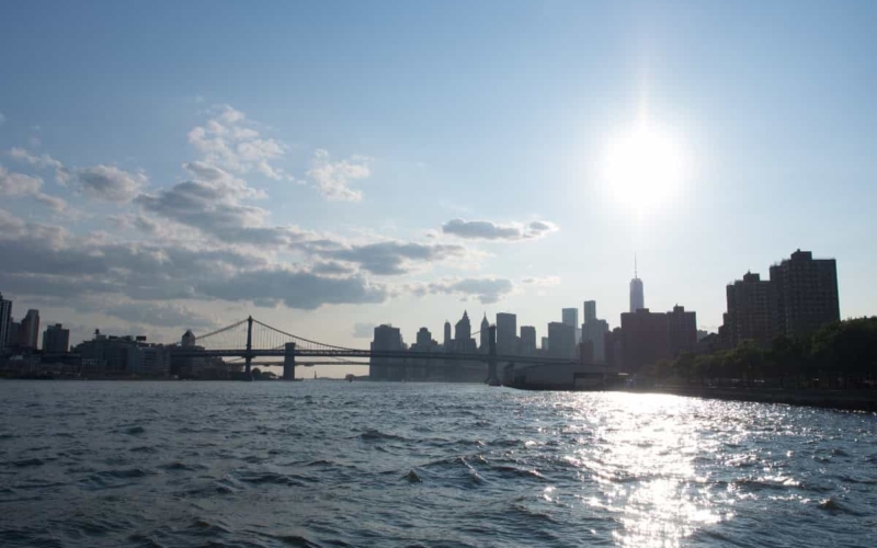 view of new york beyond bridge from water