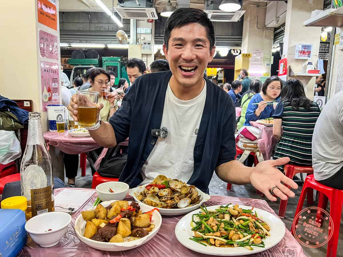 asian man enjoying dinner at oi man sang dai pai dong restaurant
