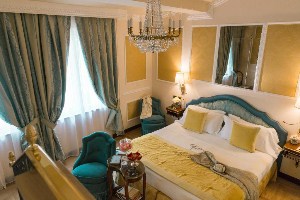 hotel bernini palace suite with chandelier, bed and sitting area