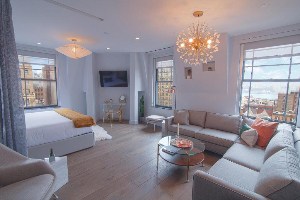 where to stay in new york hotel belleclaire central park large studio suite with bed, couches, chandeliers