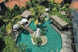 aerial view of the alantara sanur outdoor pool with bridge to island in center of pool from lounging area