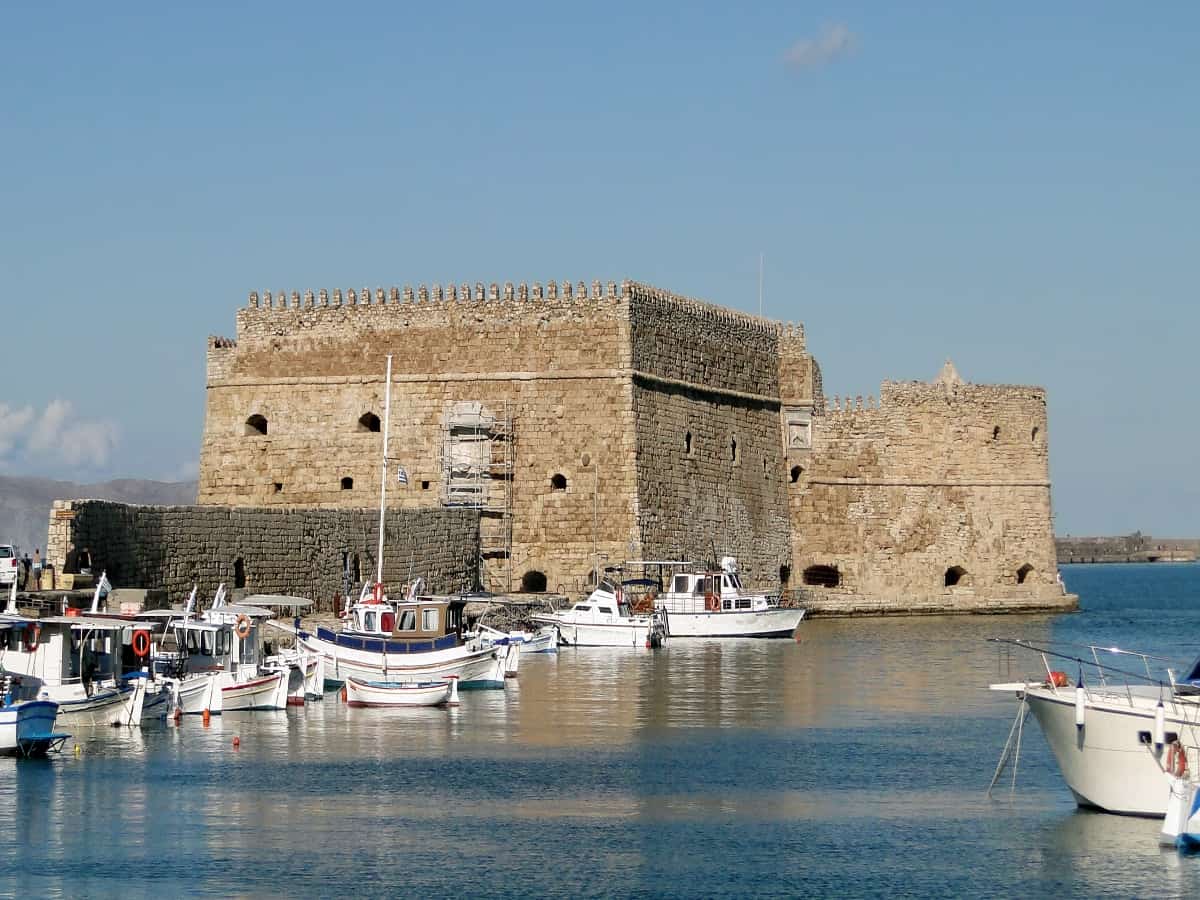 waterfront view of boats surrounding venitian fortress of koules