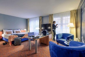 mercure hotel & residenz suite with bed table and chairs 