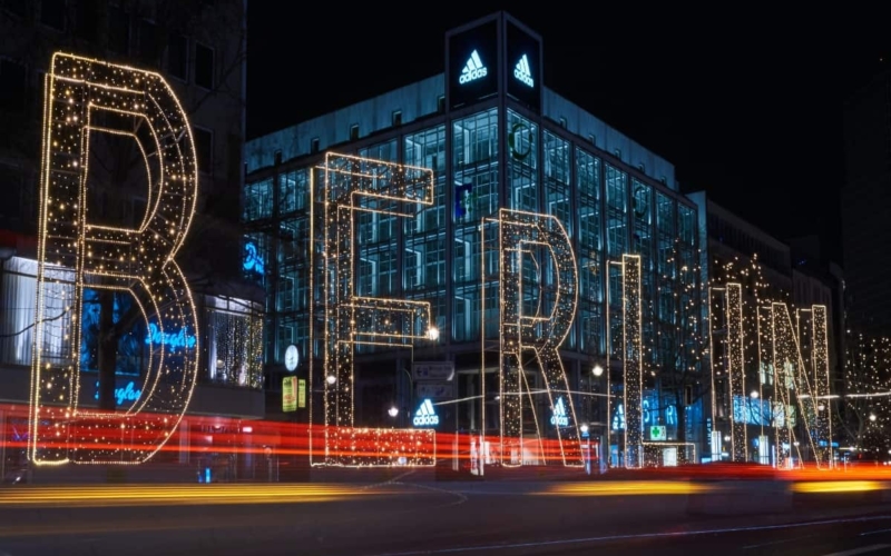 large "berlin" light lit up at night in front of city building