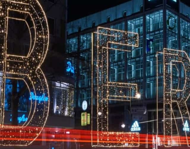large "berlin" light lit up at night in front of city building