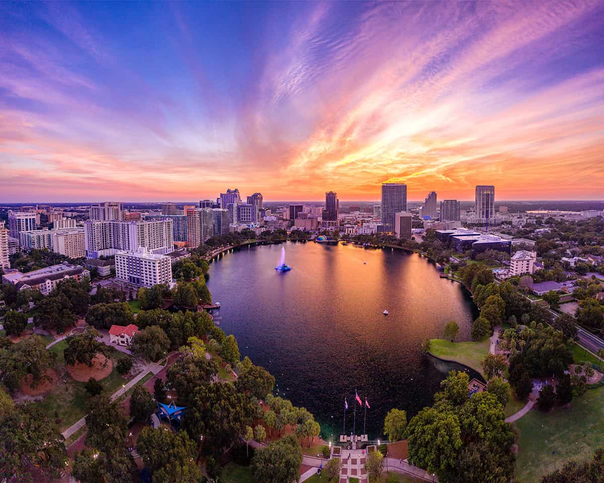 aerial view over lake eola and orlando city buildings under pretty dusk sky