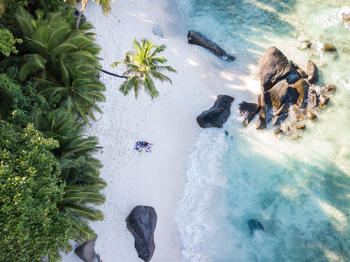 Overhead view of a white beach with crystal blue water