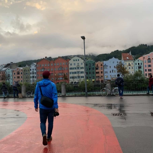 walking rain soaked street in front of colorful houses in Europe
