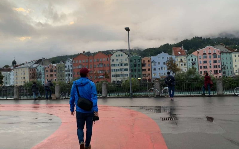 walking rain soaked street in front of colorful houses in Europe