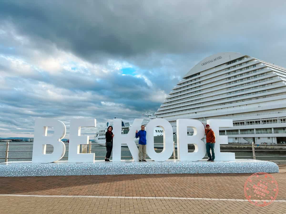 10 Day Japan Itinerary For First Timers - Modern Golden Route family of 3 posing in front of the harborland be kobe sign