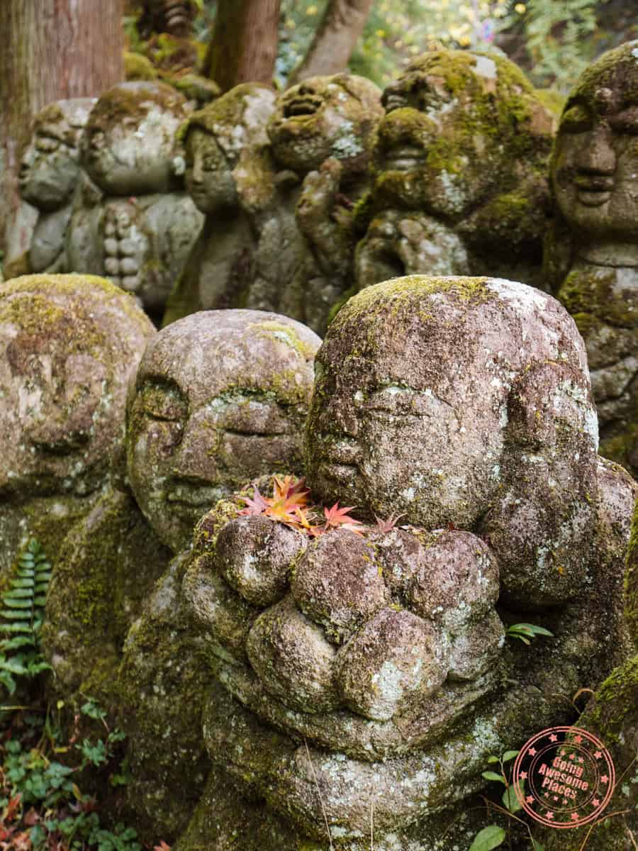 10 Day Japan Itinerary For First Timers - Modern Golden Route whimsical statue of otagi nenbutsuji temple holding small autumn leaves