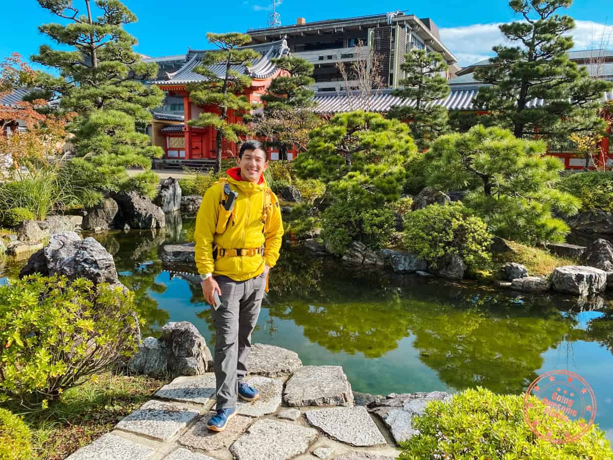 10 Day Japan Itinerary For First Timers - Modern Golden Route man standing in front of pond and garden in japan showcasing what to wear