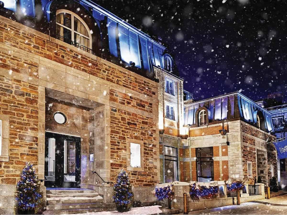 snow falling outside the auberge saint-antoine