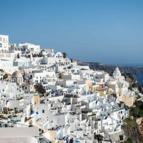 white houses sitting on the hill of santorini's coast