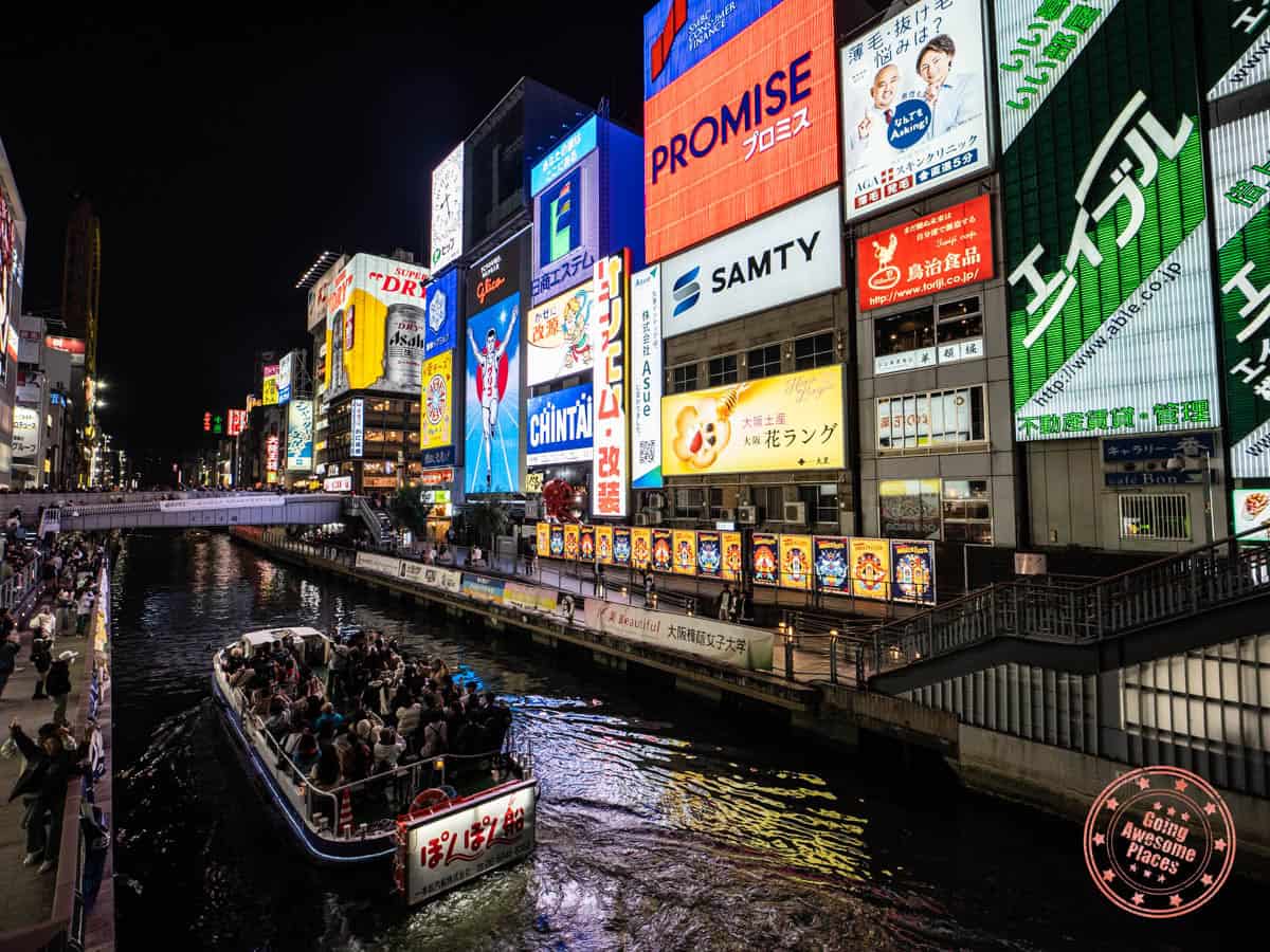 boat cruising down tonbori river through osaka
