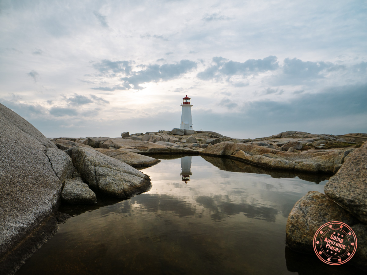 peggys cove lighthouse reflected on water at sunset